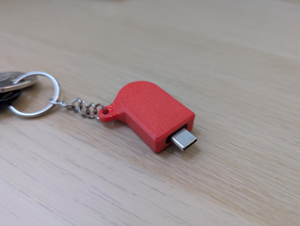 A red 3D printed case completely encloses the security key leaving only the USB-C port exposed.